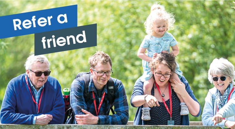 Refer a friend banner. Family enjoying a Boundless Members-day at the Wildfowl and Wetlands Trust. Mother and grandmother pointing to pond.